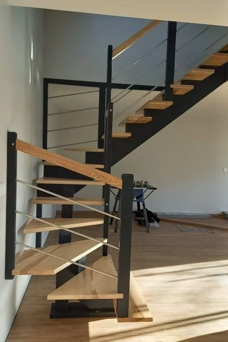 Escalier double quart tournant en bois avec limon central bois, design moderne et élégant, idéal pour un intérieur contemporain.