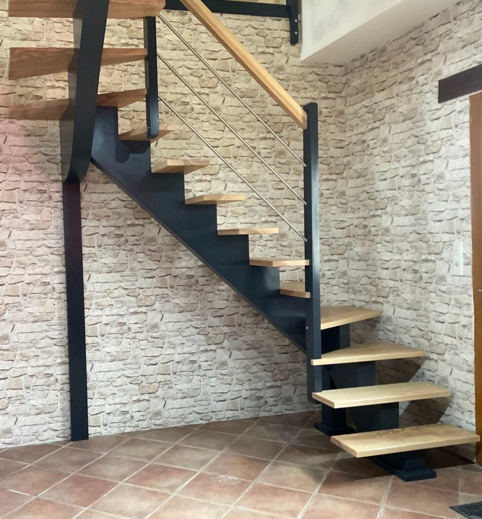 Escalier à simple limon central deux quart tournant gauche en bois et inox, installé dans une maison avec mur en pierre, escalier design. escalier en bois sur mesure à Tourouvre au Perche