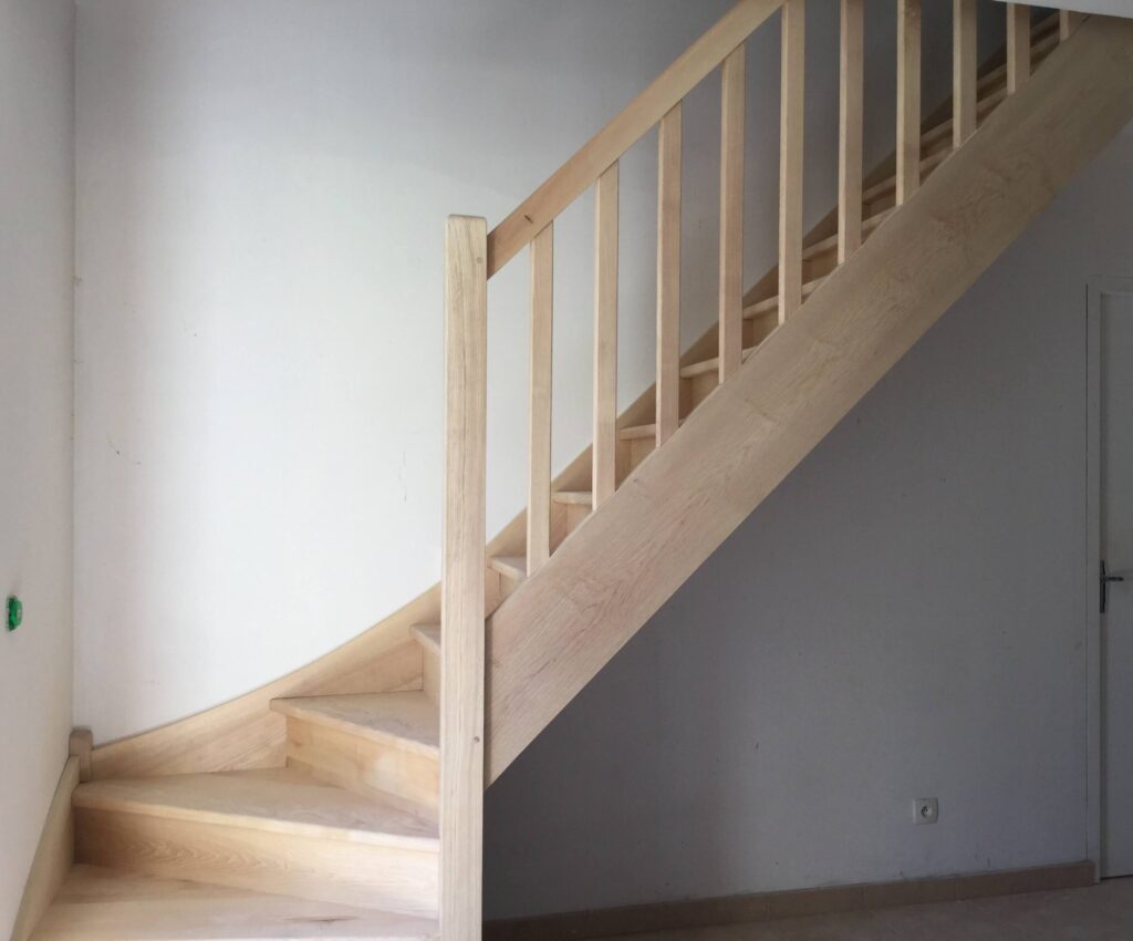 Escalier en bois quart tournant sur mesure à limon crémaillère, installé à Le Boulay-Morin, design traditionnel et finition claire. Evreux
